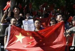 中国抗议者2012年9月14日举着反日标语在日本驻北京使馆前连续第四天示威