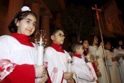 Anak-anak memegang lilin saat menghadiri misa malam Natal di sebuah gereja di Kirkuk, Irak, 24 Desember 2015. (REUTERS/Ako Rasheed)