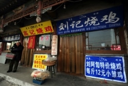 资料照:河北沧州一名回族男子走过有着汉字和伊斯兰字样招牌的清真餐馆。(2009年2月26日)