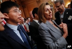 资料照片:美国众议院议长佩洛西(右)与香港活动人士黄之锋在美国首都华盛顿国会山举行香港人权问题记者会后对媒体讲话。(2019年9月18日)