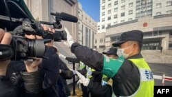 一名警察挡住记者的镜头阻止拍摄审讯公民记者张展的上海浦东新区法院外景。(2021年12月28日)