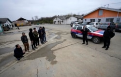 在塞尔维亚贝尔格莱德以北50公里的塞尔维亚北部城镇兹雷尼亚宁附近,在一家中国汽车轮胎工厂建筑工地打工的越南工人和塞尔维亚警察站在工房旁。(2021年11月18日)