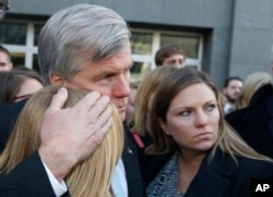 前维吉尼亚州长麦克唐纳在里士满联邦法庭外与两位女儿拥抱。他因腐败罪被判两年监禁。(2014年1月6日)