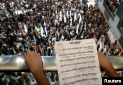 香港反送中抗议者在新城市商场手持乐谱高唱《愿荣光归香港》。(2019年9月11日)