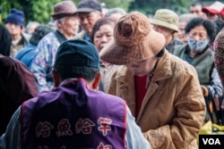 台湾人安基金会的工作人员对申请者做简单的身份识别后即送出午餐邀请单。(美国之音记者方正拍摄)