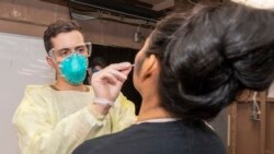 军医对罗斯福号航母上的水兵进行新冠病毒检查(美国海军2020年3月31日照片)