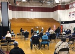 资料照片:以老人为主的民众在马里兰州蒙哥马利郡由某高中体育馆临时改建的新冠疫苗接种中心接种疫苗后坐在观察区内。(2021年3月22日)