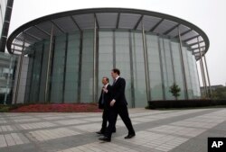 英国财政大臣乔治•奥斯本与华为公司CEO和创始人任正非在深圳参观华为总部会晤之前一道走过一座会议厅。(2013年10月16日)