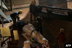 在香港大学,工人移除丹麦艺术家高志活纪念1989年天安门镇压事件受害者的雕塑“国殇之柱”的一部分,搬往一座集装箱。(2021年12月23日)