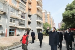中国国家主席习近平在视察武汉一个居民区时向被隔离的居民招手致意。(2020年3月10日)