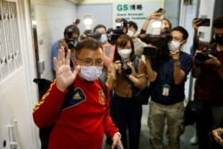 现任香港记者协会主席丶《立场新闻》副采访主任陈朗升离开《立场新闻》办公室时向媒体招手。(2021年12月19日)