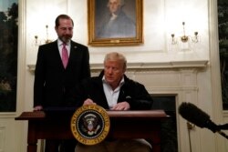 美国总统特朗普在白宫签署紧急抗疫拨款法案时,卫生部长阿扎尔站在特朗普身后。(2020年3月6日)