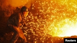 资料照:中国辽宁省大连市东北特钢厂的一名工人在工作。(2018年7月17日)