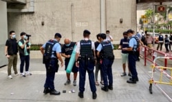 大批全副装备的军装警员在社民连十一游行起点,花了十几分钟搜查参与游行的4名社民连成员 (美国之音/汤惠芸)