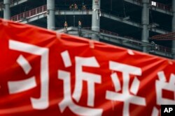 北京市中心的建筑工地与宣传习近平的横幅。(2017年4月16日)