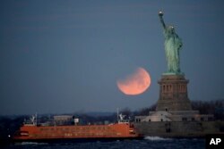 在美国纽约港口自由岛上的自由女神像和“超级月亮”（2018年1月31日）。