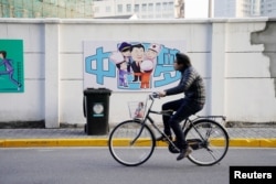 2018年2月26日,上海街道上一幅描绘中国国家主席习近平和医生、厨师、警察等人在一起的漫画,上面写着“中国梦”。