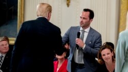 资料照片:时任互联网协会总裁兼首席执行官的贝克曼在白宫一次行政令签署仪式上与时任总统的特朗普握手。(2018年7月19日)