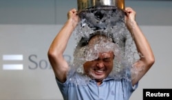 为唤起公众对罕见病“渐冻人症”的关注,很多公众人物和普通民众都参与了“冰桶挑战”公益活动。参与者要往自己身上浇冰水然后提名三位好友接受挑战。被提 名者可以选择接受挑战,向公益组织捐款或者既接受挑战又捐款。图为当地时间8月20日日本软银集团总裁孙正义在东京总部接受冰桶挑战。