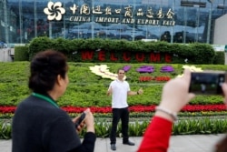 资料照:参观者在广州举行的中国进出口商品交易会前留影。(2018年4月15日)