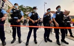 社民连十一游行终点湾仔金紫荆广场对开,大批评全副武装的警员戒备,并且拉起封锁线封路 (美国之音/汤惠芸)