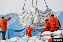 2018年3月22日,中国江苏省南通港口工人装卸进口的大豆产品。 中国4月3日宣布将对包括大豆在内的价值500亿美元的美国商品加征关税,报复川普政府前一日公布的对中国商品增收关税清单。