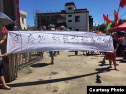 乌坎村民拉横幅抗议当局抓捕村长林祖恋。(推特图片)