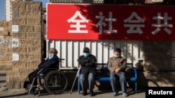 几位老人坐在北京街头晒太阳。(2020年11月3日)