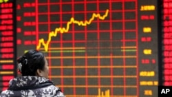 2016年1月29日,中国安徽省一名投资者正在查看证券公司的电子显示屏上的股票信息。