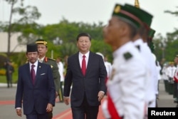 中国国家主席习近平和文莱元首哈桑纳尔苏丹的陪同下检阅文莱仪仗队。(2018年11月19日)