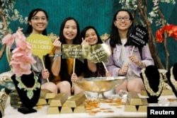 2018年8月10日,在加利福尼亚州洛杉矶举行的韩国文化和音乐会展中,《疯狂亚洲富豪》展位的人员。她们手持标语:“必须看”“带笑的疯狂”“我一直笑,笑到哭了”