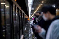 春节假期后,上海地铁站戴着口罩的人群在等车。(2020年2月10日)