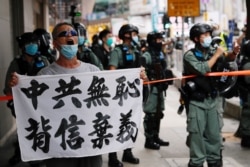 一名香港抗议者在主权回归纪念日举行的抗议港版国安法游行中举牌指责中共背信弃义。(2020年7月1日)