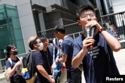 2019年6月21日香港民主活动人士黄之锋在警察总部外抗议时发表讲话,要求香港领导人下台,并撤回引渡法案。