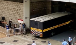 有声援唐英杰的市民质疑当局安排多部囚车出入高等法院,企图误导支持者,不能送别押解唐英杰到监狱的囚车(美国之音/汤惠芸)