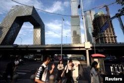 人们走近北京中央商务区的中央电视台(CCTV)大楼附近(2018年8月16日)