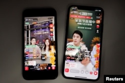 在阿里巴巴淘宝app上做直播的两名直播员(李佳琦,右图)。(2021年12月14日)