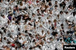 2018年6月28日,美国华盛顿,移民活动人士游行到国会山之后,在哈特参议院办公楼内抗议示威,用白色毯子包裹自己,象征着在德克萨斯州美国 - 墨西哥边境拘留所用类似毯子包裹的移民儿童。