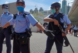 当香港首位被控涉嫌违反国安法的唐英杰坐着轮椅被押解至法院时港警戒备。(2020年7月6日)