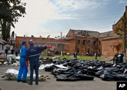 袭击过后,紧急救援人员将遇难者尸体移至学校外空地暂时停放