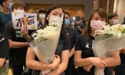 大批参与悼念梁凌杰逝世一周年的市民身穿黑衣，系上白丝带，献上白色的鲜花。 (美国之音/汤惠芸)