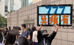排队人士高举示威标语,抗议当局以莫须有罪名控告47名民主派人士 (美国之音/汤惠芸)
