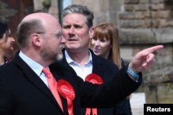 资料照: 英国议会下院跨党派商业及贸易委员会主席、曾任工党内阁大臣的利亚姆·伯恩( 左 Liam Byrne)与英国现任首相斯塔默(中 Keir Starmer)在一个竞选集会上。(2021年5月21日)