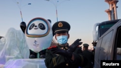 一名中国武警在北京的冬奥会吉祥物前给拍照者做手势。(2022年1月15日)