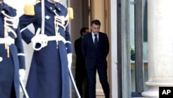 2025年2月17日,法国总统埃马纽埃尔·马克龙(右)在巴黎爱丽舍宫等候参加有关乌克兰会议的欧盟主要国家和英国领导人。