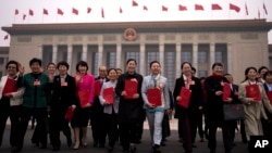 2025年3月11日出席全国人民代表大会闭幕式后,手捧全国人民代表大会报告的代表离开人民大会堂。