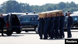 A coffin of one of the victims of Malaysia Airlines MH17 downed over rebel-held territory in eastern Ukraine, is loaded into a hearse on the tarmac during a national reception ceremony at Eindhoven airport July 23, 2014. Two aircraft carrying the remains