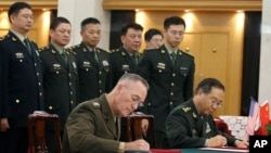 美军参联会主席邓福德上将(前左)与中国中央军委联合参谋部参谋长房峰辉在北京签署协议。 (2017年8月15日)