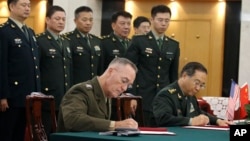 美军参联会主席邓福德上将(前左)与中国中央军委联合参谋部参谋长房峰辉在北京签署协议。 (2017年8月15日)