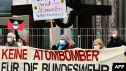 国际废除核武器运动(ICAN)和其他和平倡议的反核活动人士在柏林挥舞着51面参与联合国禁止核武器条约国家的旗帜举行抗议。(2021年1月22日)